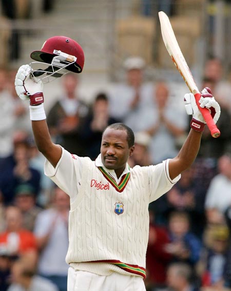 brian lara holding a bat and helmet