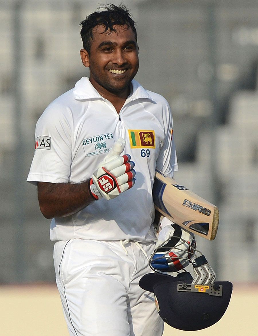 MAHELA JAYAWARDENE in white uniform holding a wooden bats